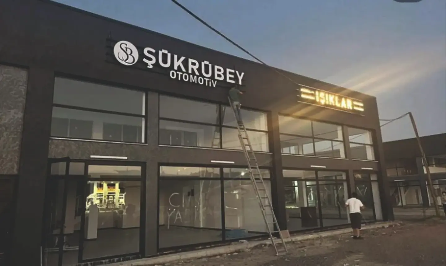 Enver Reklam ekibi Şükrübey Otomotiv cephesine ışıklı kutu harf tabela monte ederken
